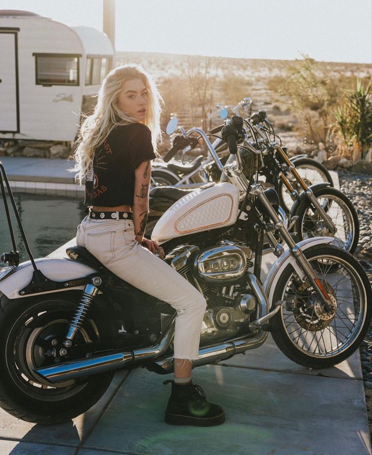 a woman sitting on top of a motorcycle