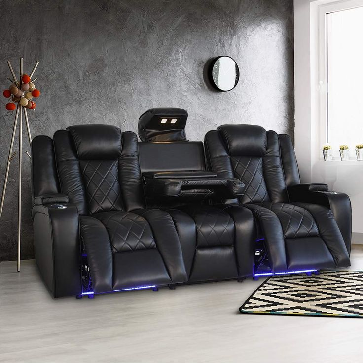 a living room with two recliners and a tv on the wall in front of it