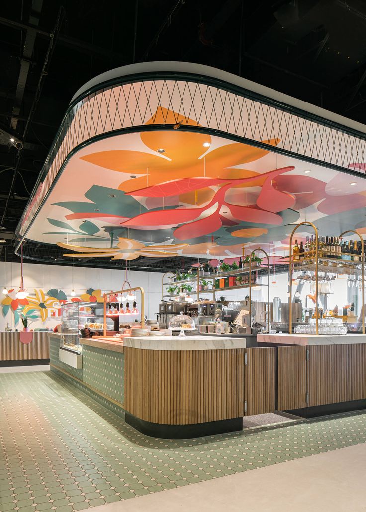 the interior of a restaurant with colorful umbrellas hanging from the ceiling