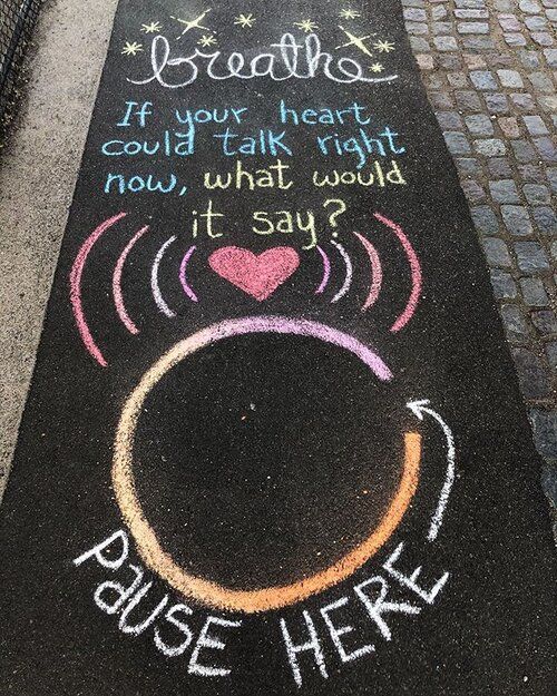 chalk drawing on the sidewalk with words written in it