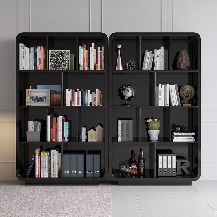 two black bookshelves filled with lots of books on top of a white floor