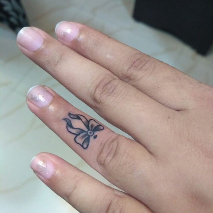 a person's hand with a flower tattoo on it