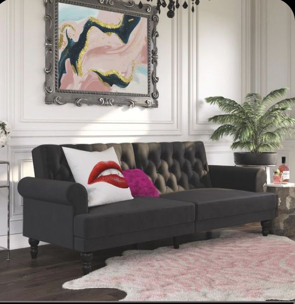 a living room with a couch, rug and painting on the wall