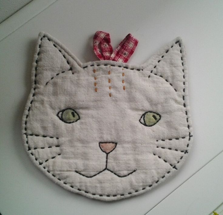 a close up of a cat face on a piece of cloth with a red ribbon