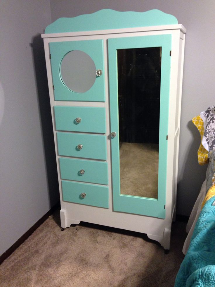 a blue and white armoire next to a bed