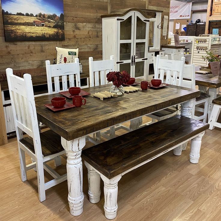 a wooden table with white chairs and benches