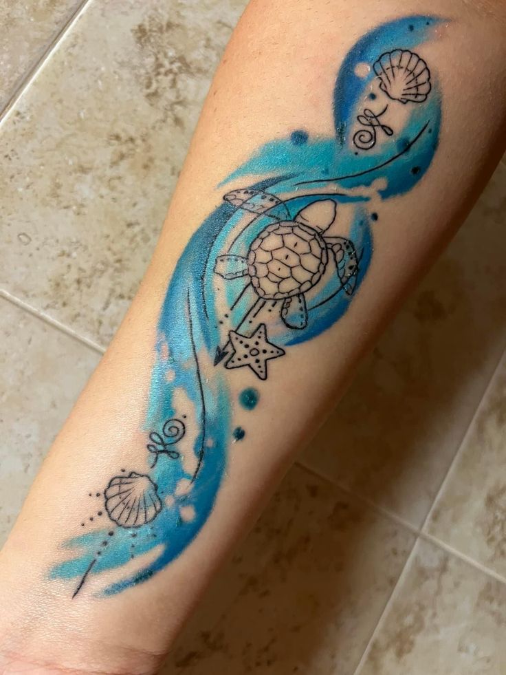 a person with a tattoo on their arm that has an image of a turtle in the ocean