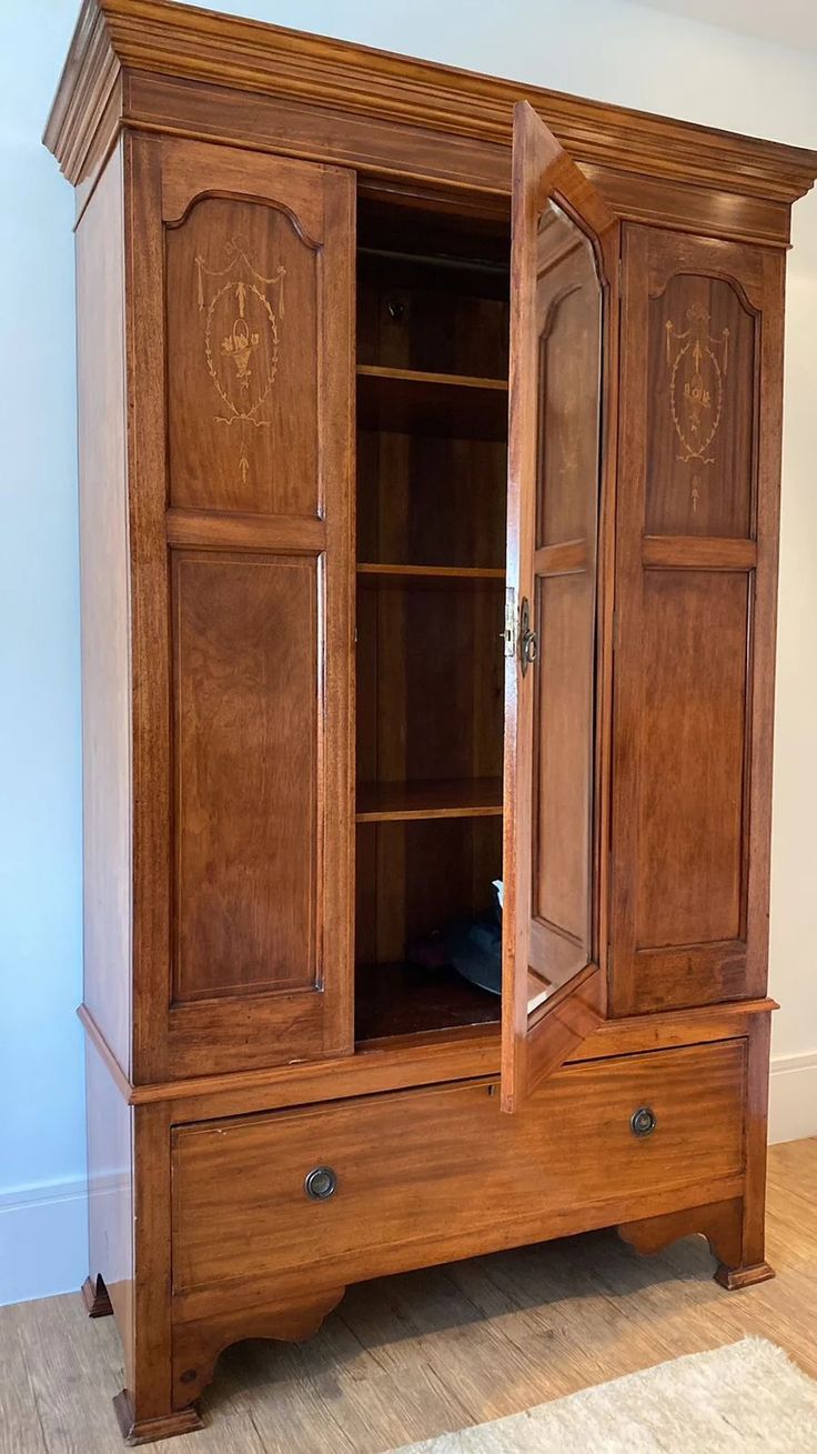 a wooden armoire sitting on top of a hard wood floor