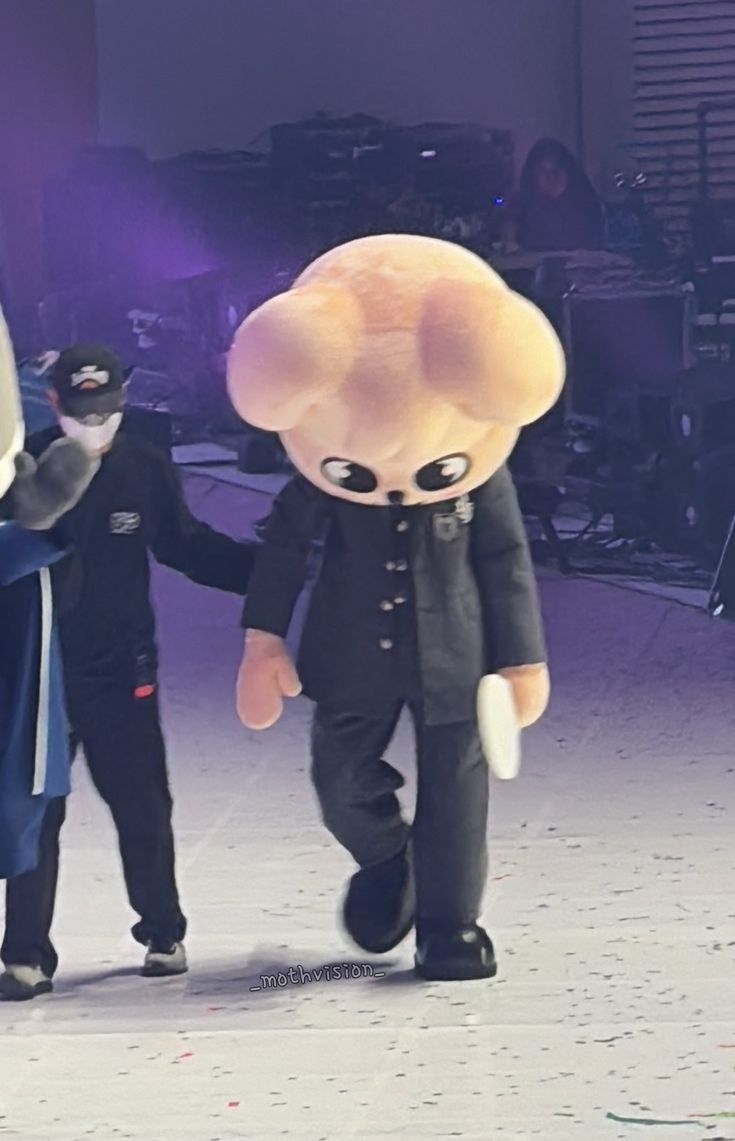 two people in costumes walking down a stage with one holding the hand of another person's hand