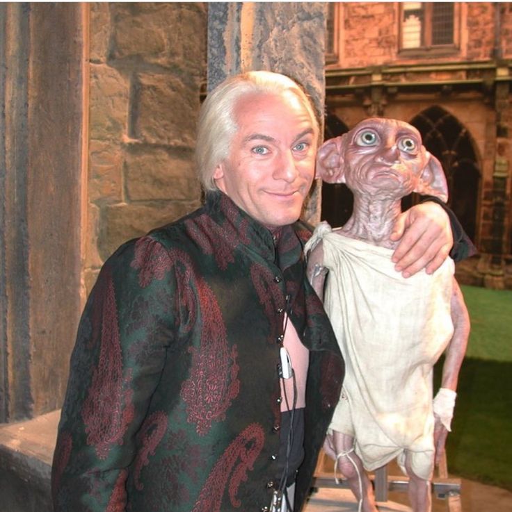 a man standing next to an animal statue