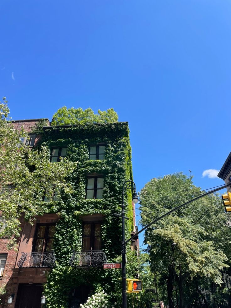 an apartment building covered in vines on a sunny day