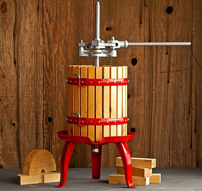 a red and wooden wine press sitting on top of a table