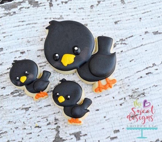 three decorated cookies in the shape of birds