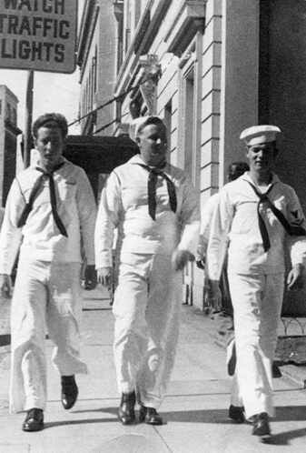 three men in white suits walking down the street with their ties tied to their chests