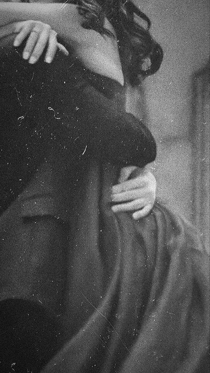 a black and white photo of a woman with her arm around a man's neck