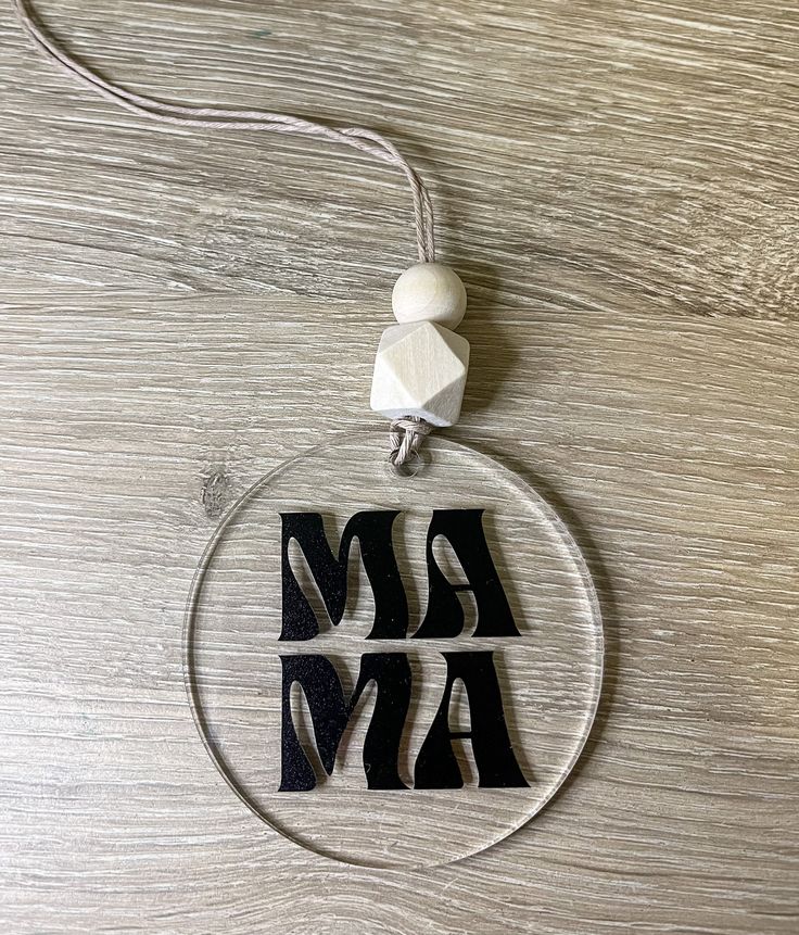 an acrylic ornament with the word mama in black and white letters