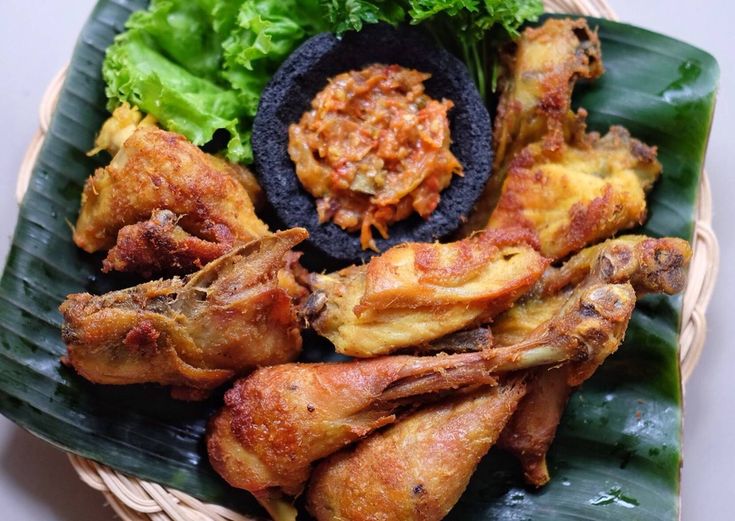 a basket filled with different types of food on top of a green leafy plate