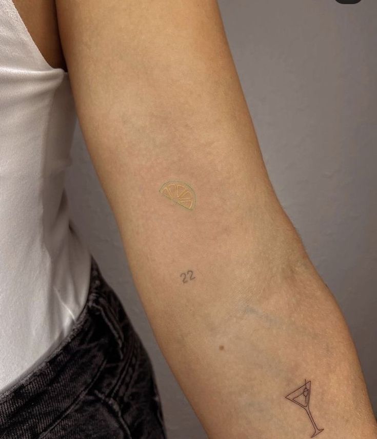 a woman's arm with a small tattoo on the left side of her arm