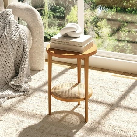 a living room scene with focus on the end table and books in front of the window