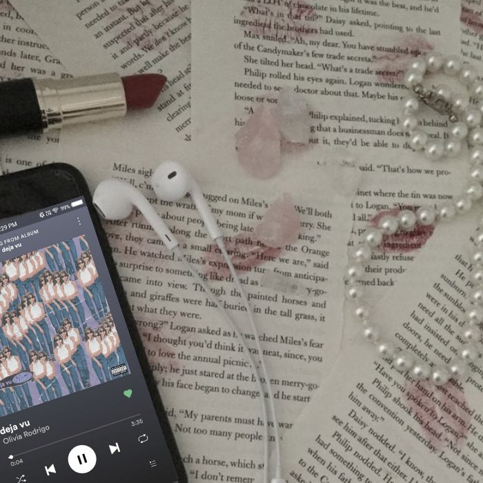 an mp3 player sitting on top of a book next to earbuds and beads