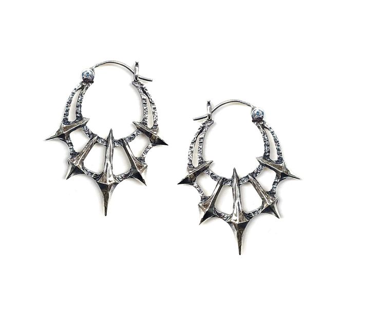 Add some gothic style to your wardrobe with these unique Chaos Earrings. Made in sterling silver, these earrings feature 5 spikes contrasted by a heavy textured crescent. Dimensions These earrings are 45mm long x 36mm wide and 5mm thick Each earring weighs approximately 6.5grams Gothic Silver Jewelry, Edgy Metal Festival Earrings, Festival Edgy Earrings For Pierced Ears, Edgy Handmade Silver Earrings, Edgy Silver Earrings For Festival, Silver Gothic Plug Earrings For Festival, Edgy Sterling Silver Earrings, Edgy Sterling Silver Pierced Earrings, Gothic Oxidized Metal Earrings