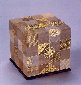 a wooden box with gold designs on it's sides and an intricate design on the lid