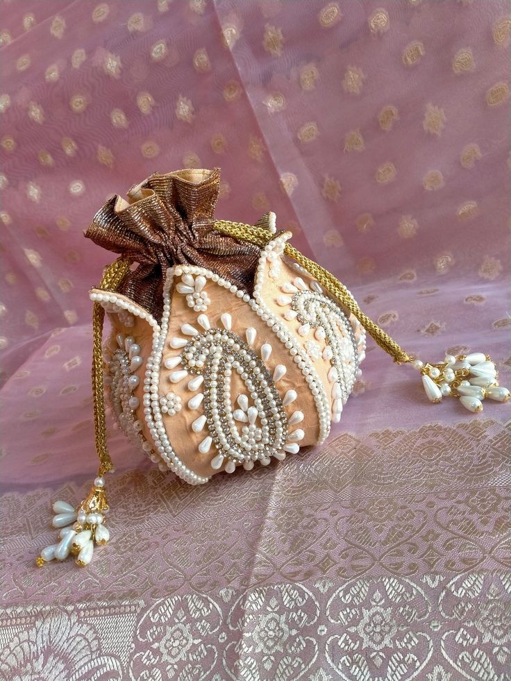 a small purse with pearls on it sitting on a table