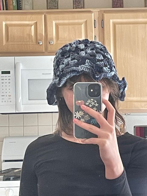 a woman taking a selfie in the kitchen with her cell phone up to her ear