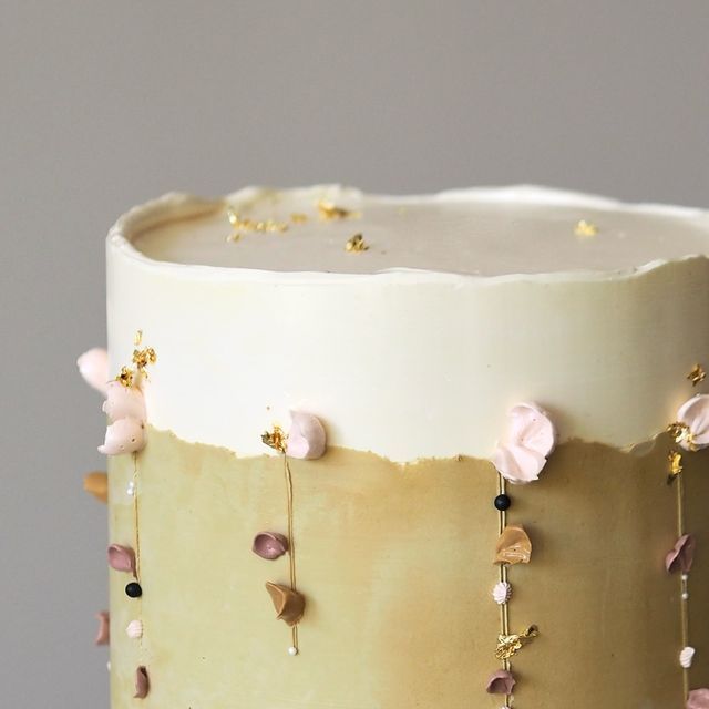 a close up of a cake with flowers on it's side and gold sprinkles