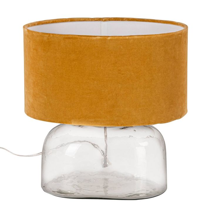 a lamp that is on top of a glass jar with a yellow shade over it