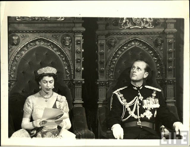 an old black and white photo of a man in uniform sitting next to a woman