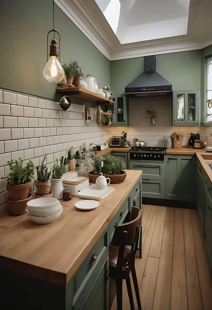 a kitchen filled with lots of green cabinets and wooden counter top next to a stove top oven