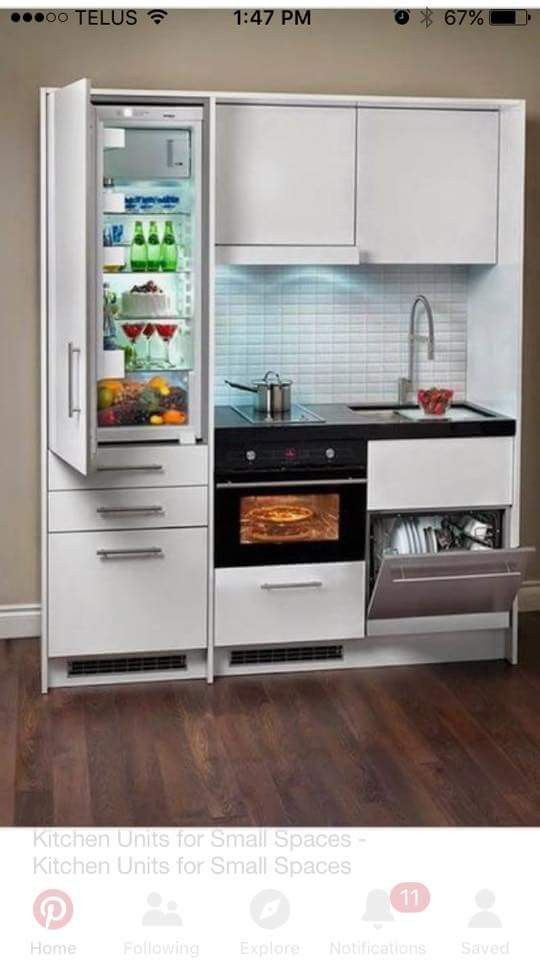 an open refrigerator in the middle of a kitchen with white cabinets and wood flooring