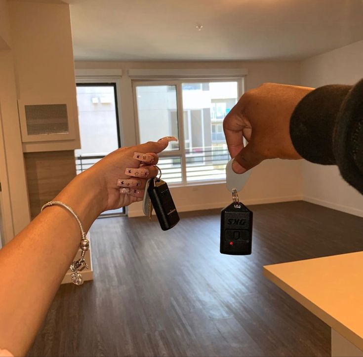 two people reaching out their hands to each other in an empty room with wooden floors