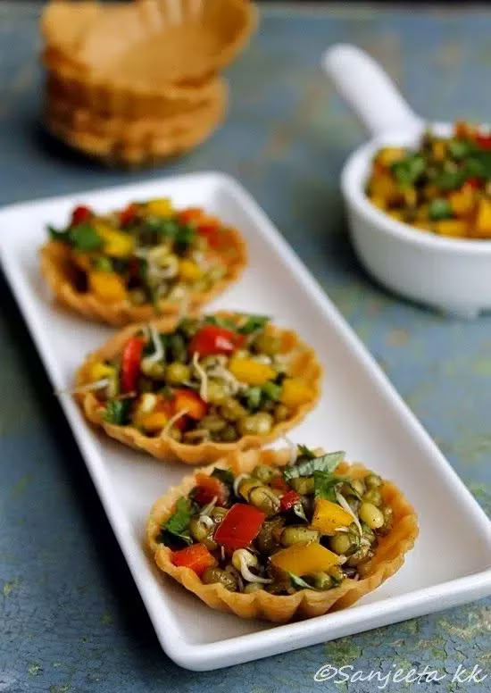 three small appetizers are sitting on a white plate next to some crackers