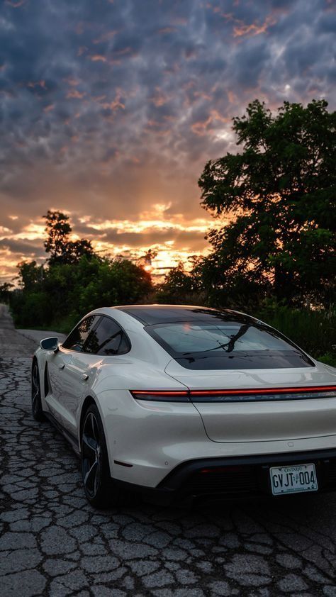 a white sports car is parked on the side of the road at sunset or dawn