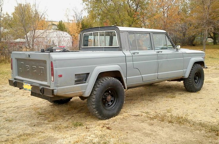 a gray truck parked on top of a dirt field