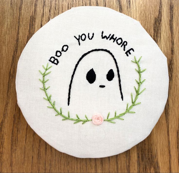 a white embroidered badge with the words boo you where and a ghost face on it