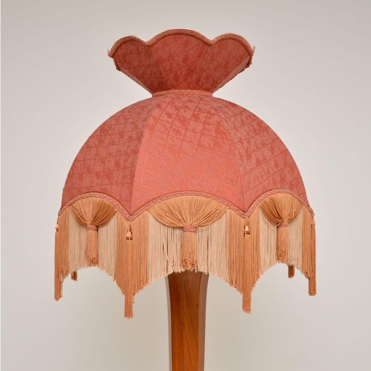 an old fashioned lamp with fringes on it