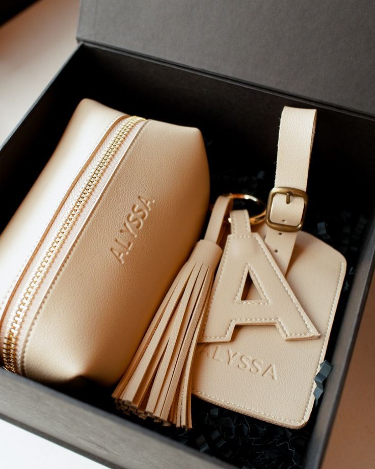 a tan purse and keychain in a box with a tassel on it