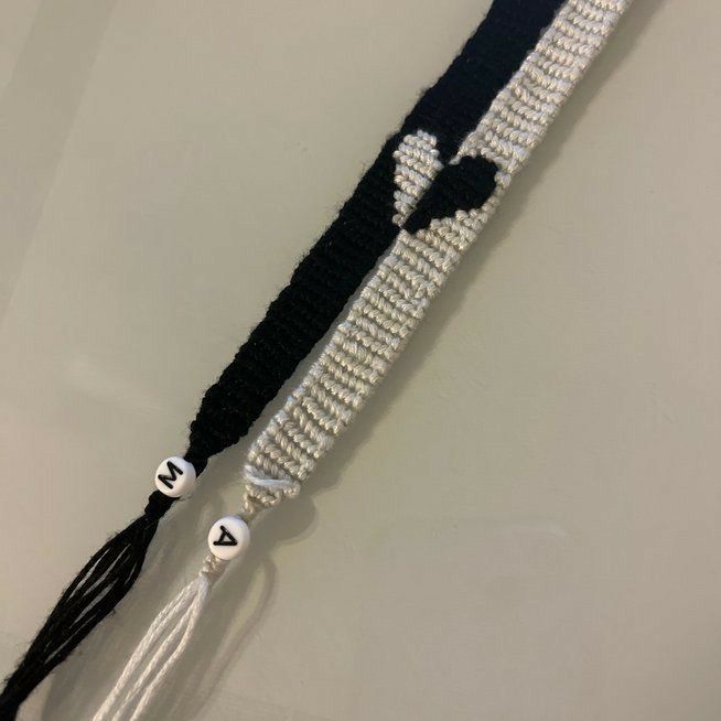 a black and white beaded lanyard with tassels hanging from it's side