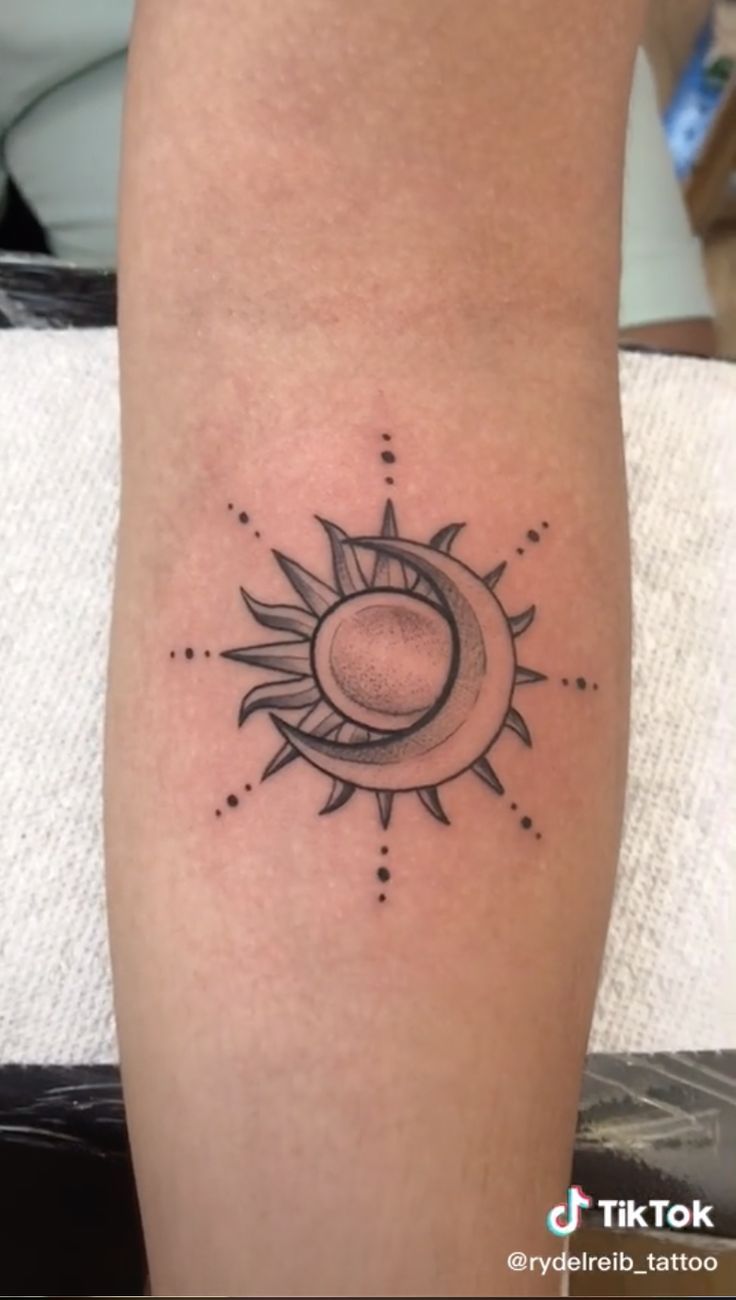 a small sun and moon tattoo on the leg