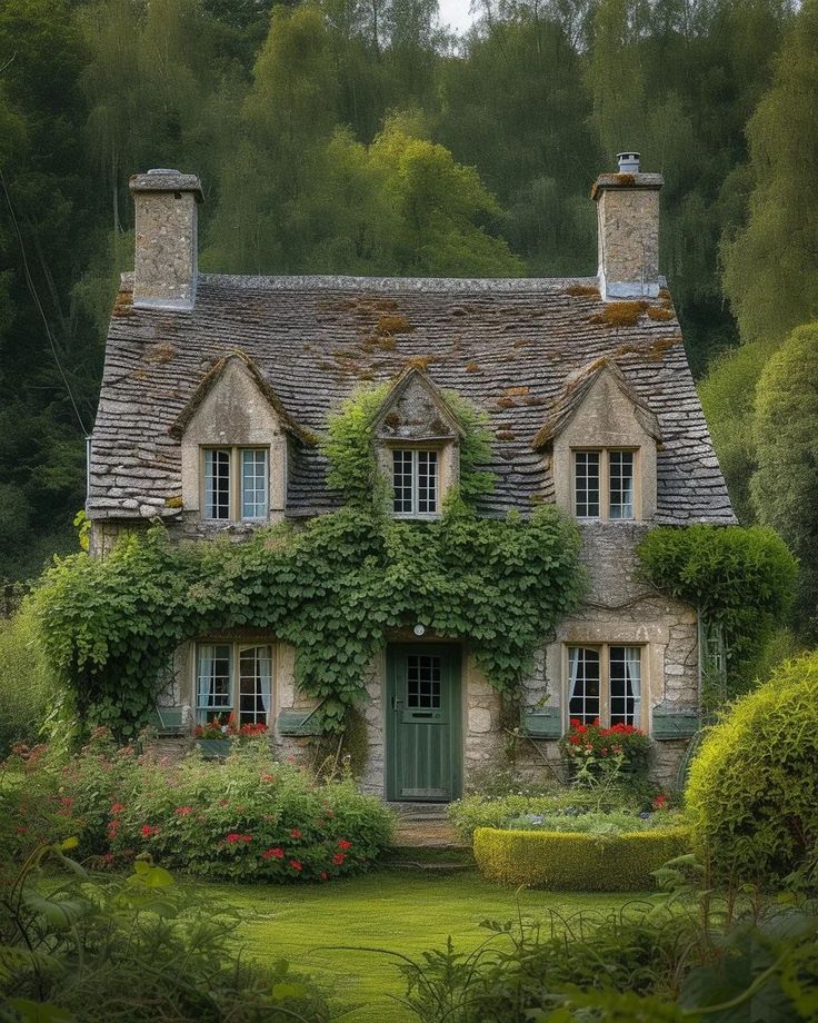 an old stone house with ivy growing on it's roof and windows, surrounded by greenery