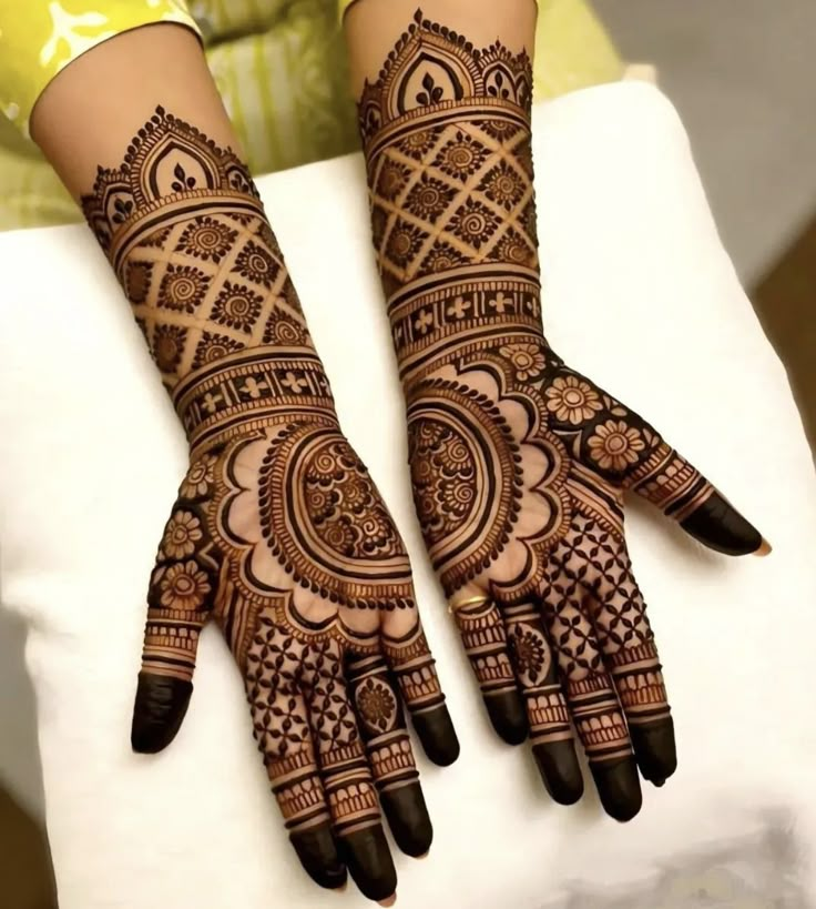 two hands with henna tattoos on them