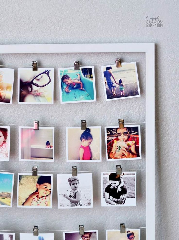 a white frame with photos pinned to it's sides and magnets attached to the wall