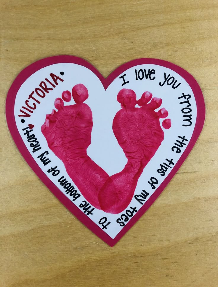 a heart shaped sticker with a hand and foot imprint on it