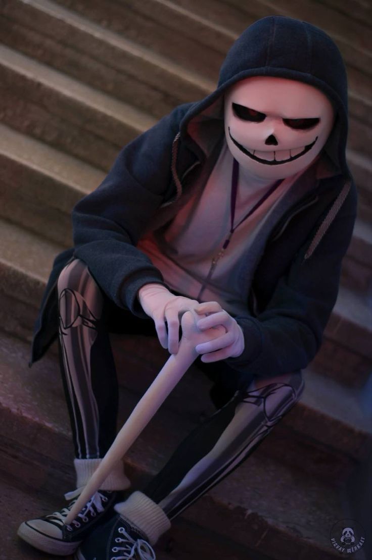 a person in a skeleton costume sitting on some steps with a baseball bat and shoes