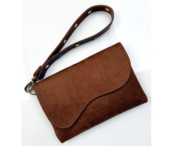 a brown suede purse sitting on top of a white table