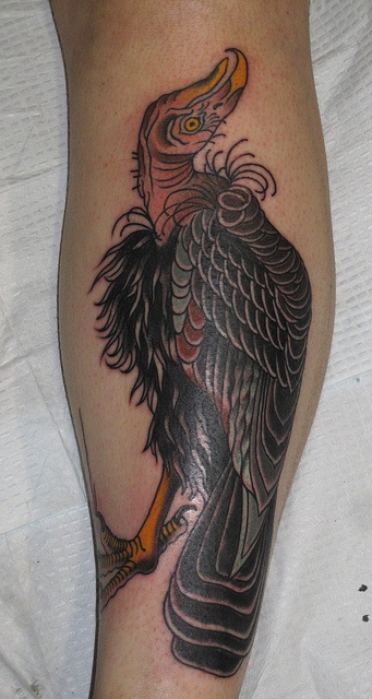 an eagle tattoo on the leg of a person's leg, it is black and grey