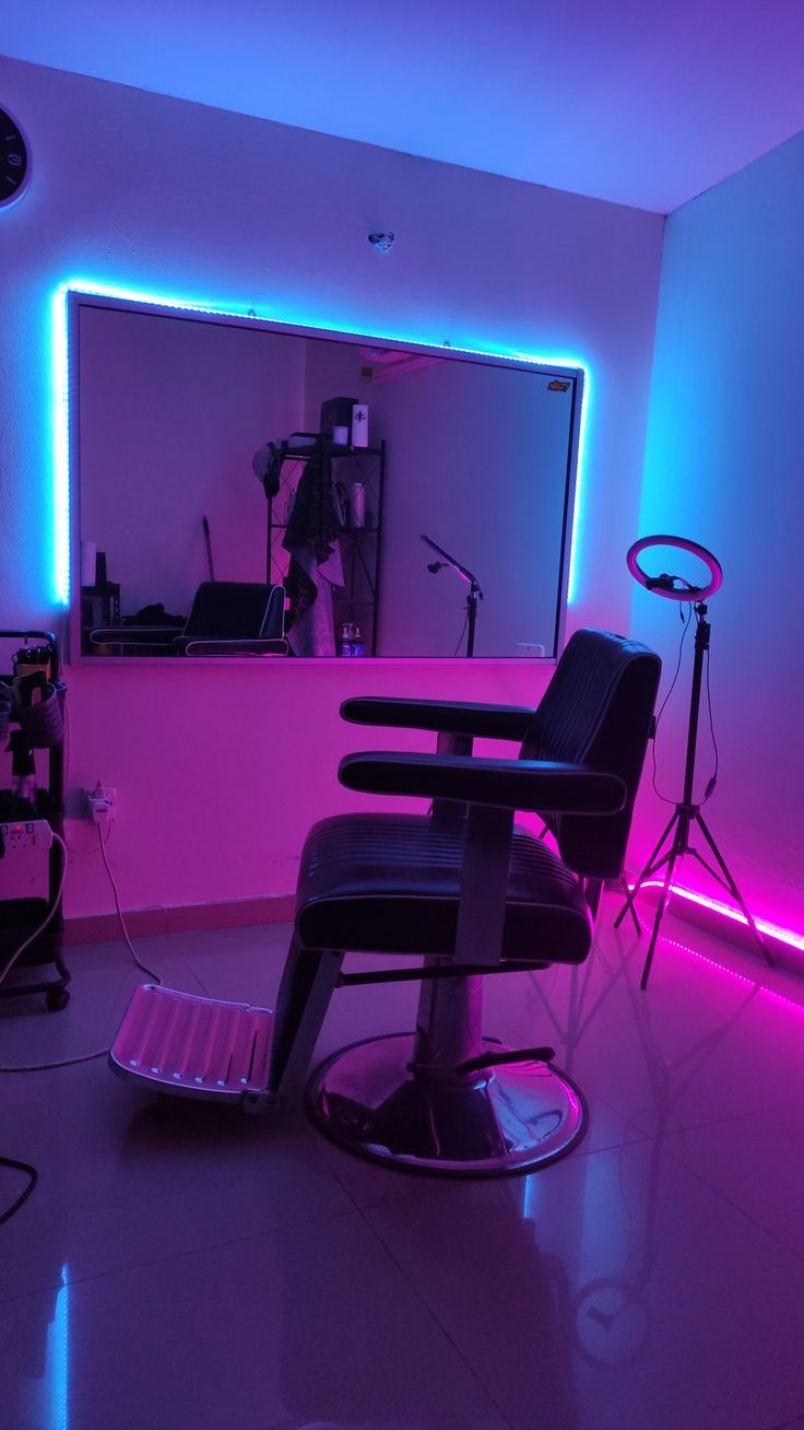 a chair in the middle of a room with neon lights around it and a mirror behind it